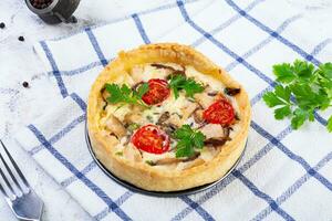 delizioso quiche con pollo incontrare, funghi, pomodori e erbe aromatiche foto