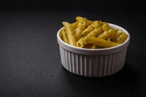 delizioso fresco pasta penne con verde pesto salsa con basilico, sale e spezie foto