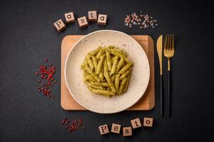 delizioso fresco pasta penne con verde pesto salsa con basilico, sale e spezie foto