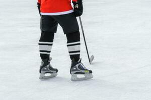 hockey giocatore con un' bastone in piedi su ghiaccio foto