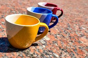 tempo di cerimonia per tè e caffè.colorato tazze su rosso marmo superficie foto