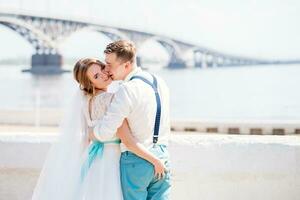 il sposa e sposo siamo fotografato su il sfondo di il ponte foto