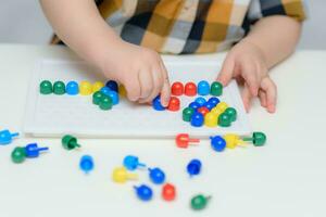 il bambino giochi con un' mosaico seduta a un' tavolo foto