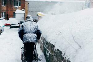 uomo pulisce il cortile rimuove spazzaneve foto