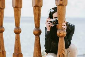 attraente ragazza prende immagini con un vecchio telecamera foto