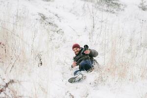 allegro viaggiatore fotografo scivolato e abbattere su neve foto