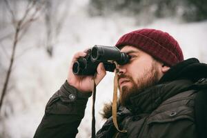 viaggiatore guardare attraverso binocolo nel il inverno foto