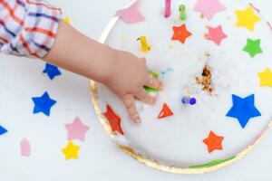 poco bambino tocchi il suo compleanno torta quale bugie su il tavolo foto