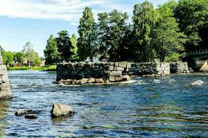 un' fiume con rocce e alberi nel il sfondo foto