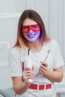 bellissimo ragazza ortodontista in posa con strumenti nel clinica foto