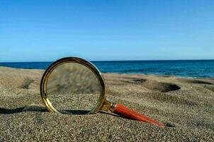 ingrandimento bicchiere su il spiaggia foto