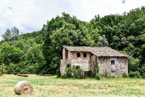 un vecchio pietra Casa nel il mezzo di un' campo foto