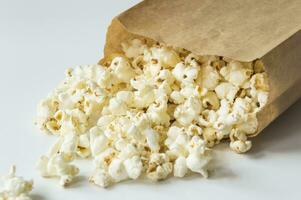 Popcorn nel un' Marrone carta Borsa su un' bianca superficie foto