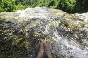 un' dell'uomo piedi nel il cascata. rilassante tempo con natura.buono sana,pacifica.foto concetto in viaggio e stile di vita. foto