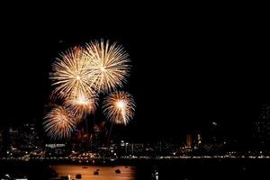 molti fuochi d'artificio lampeggianti con sfondo paesaggio urbano notturno festeggiano il nuovo anno. foto