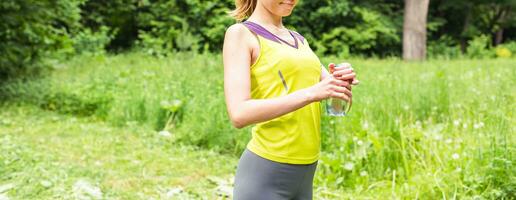 fitness donna potabile acqua dopo opera su esercizio su estate all'aperto ritratto foto