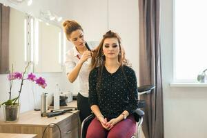 parrucchiere fare taglio di capelli per donne nel parrucchiere salone. concetto di moda e bellezza. positivo emozione. foto