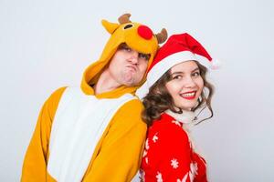 contento giovane donna nel Santa Claus cappello e uomo nel carnevale costume di cervo. divertimento, vacanza, scherzo e Natale concetto foto