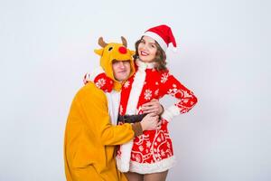 contento giovane donna nel Santa Claus cappello e uomo nel carnevale costume di cervo. divertimento, vacanza, scherzo e Natale concetto foto