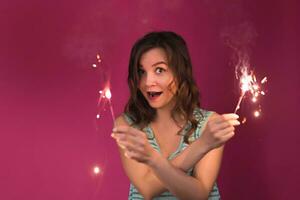 ritratto di giovane attraente festeggiare donna Tenere sparklers foto