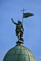 un' statua di un' uomo Tenere un' bandiera su superiore di un' cupola foto