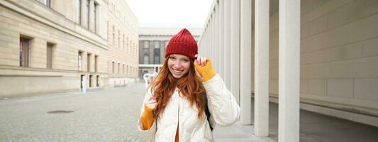 contento testa Rossa ragazza, turista andando in giro cittadina, esplorando sospiro posti nel città, backpacking in giro Europa, gode in viaggio foto