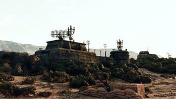 un' deserto paesaggio con rocce e alberi circostante un' militare base guerra bunker foto