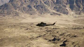 un' elicottero volante al di sopra di un' montagna gamma nel il deserto foto