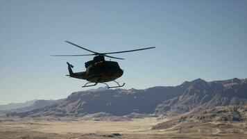 un' elicottero volante al di sopra di un' montagna gamma nel il deserto foto