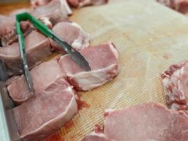 carne cruda fresca, carne di maiale tagliata a pezzi per la vendita nel mercato alimentare foto