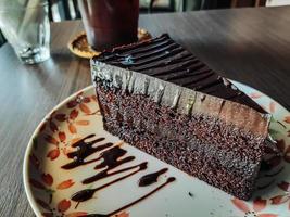 piatto con fetta di gustosa torta al cioccolato fatta in casa sul tavolo, deliziosa torta al cioccolato. pezzo di torta su un piatto. cibo dolce. dolce da dessert. avvicinamento. foto