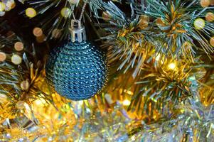 Natale sfondo con Natale albero rami, blu sfera, argento orpello nel il leggero di d'oro ghirlanda foto