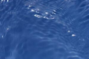 acqua blu bolle su il superficie increspature. defocus sfocato trasparente bianco nero colorato chiaro calma acqua superficie struttura con spruzzo e bolle. acqua onde con splendente modello struttura sfondo. foto