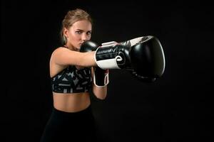 bellissimo femmina atleta nel boxe guanti, nel il studio su un' nero sfondo. messa a fuoco su il guanto foto