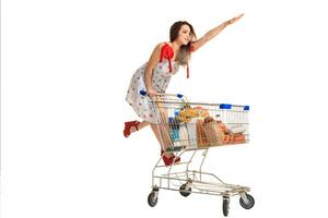 donna con shopping carrello pieno con prodotti isolato al di sopra di bianca sfondo foto