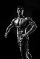 muscolare e in forma giovane bodybuilder fitness maschio modello in posa ove foto