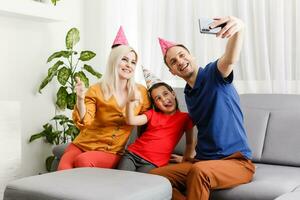 famiglia celebra compleanno in linea. mamma papà bambini a casa mobile Telefono video chiamata auto-isolamento. festa nuovo tecnologia gadget. coronavirus messo in quarantena. foto