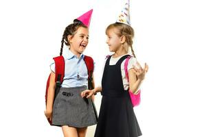 Due compleanno ragazze nel camicia blu scuola uniforme vestiti cappello isolato su bianca sfondo bambini studio ritratto. infanzia bambini formazione scolastica stile di vita concetto. finto su copia spazio foto