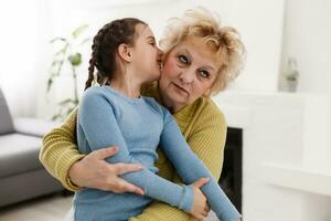 nipotina e nonna felice che danno il cinque divertendosi a giocare insieme seduti sul divano, sorridente nonna nonna e nipote in età prescolare che ridono celebrando i buoni rapporti a casa foto