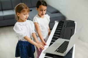 casa lezione su musica per il ragazza su il pianoforte. il idea di attività per il bambino a casa durante quarantena. musica concetto foto