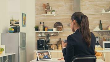 attività commerciale donna nel un' video chiamata con sua padre durante sua padre mentre mangiare prima colazione. utilizzando moderno in linea Internet ragnatela tecnologia per Chiacchierare attraverso webcam video conferenza App con parenti, famiglia, amici e collaboratori foto