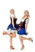 un' pieno lunghezza ritratto di Due bellissimo donne nel un' tradizionale costume isolato su bianca. oktoberfest foto