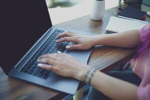 indietro Visualizza di un' giovane rosa capelli donna tastiera su il computer portatile comp foto