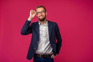 ritratto Visualizza di un attraente contento uomo d'affari con bicchieri su un' rosa sfondo foto