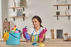 bellissimo allegro brunetta donna nel guanti pulizia moderno cucina foto