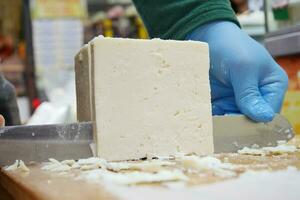 lavoratore affettare il formaggio su tavolo , foto