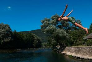 un' uomo nel un' costume da bagno è salto in il acqua foto