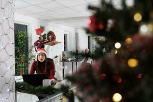 dipendente di partenza nuovo lavoro nel festivo decorato ufficio, saluto colleghi. lavoratore contento dopo accettare nuovo azienda posizione, incontro colleghi per primo tempo nel Natale ornato spazio di lavoro foto