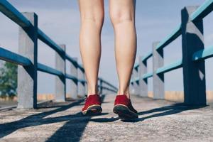 donna indossare scarpe da corsa per camminare e correre su sfondo verde natura. esercizio di salute. foto