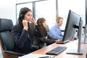 gruppo di agente operatore di call center di giovane professione con cuffie che lavorano in ufficio. persone del servizio di telemarketing aziendale che si concentrano sul lavoro di conversazione e parlano con il cliente amichevole foto